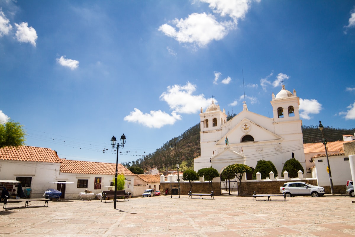 White church and buildings in a sunny town square.
