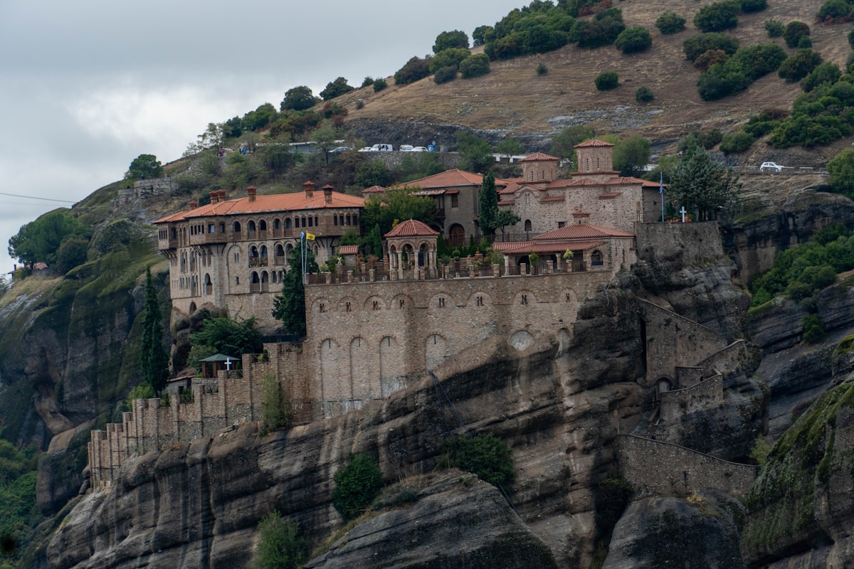 a castle on top of a cliff with a mountain in the background
