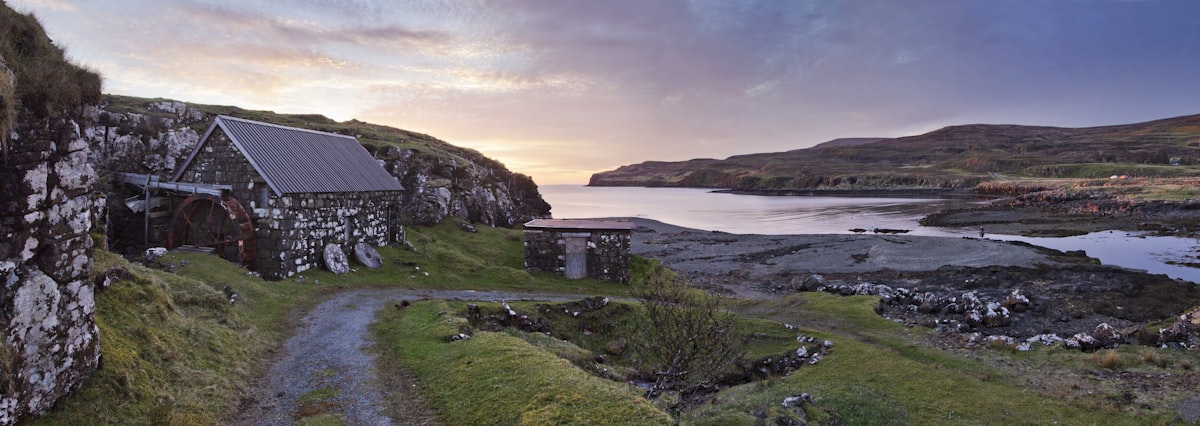 A stone building sitting on top of a lush green hillside
