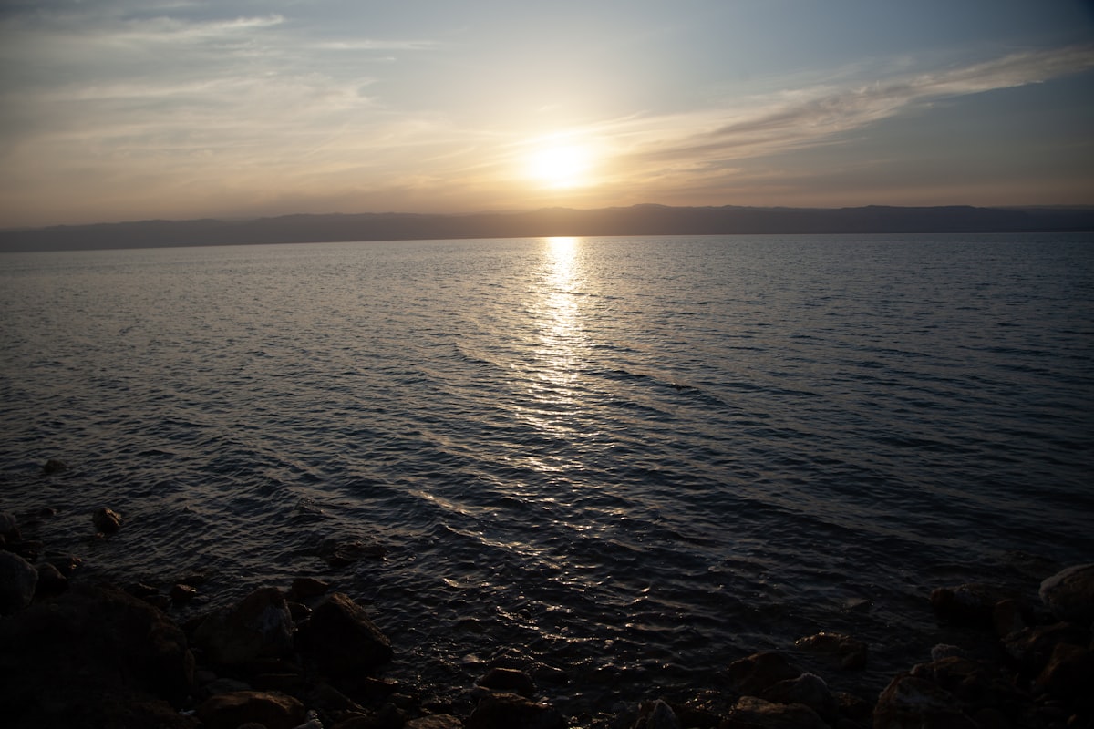 the sun is setting over a body of water