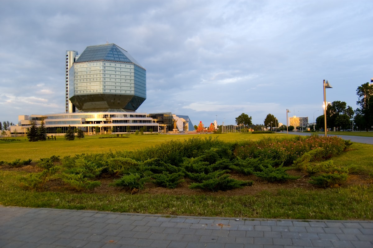 blue glass building near green grass field during daytime