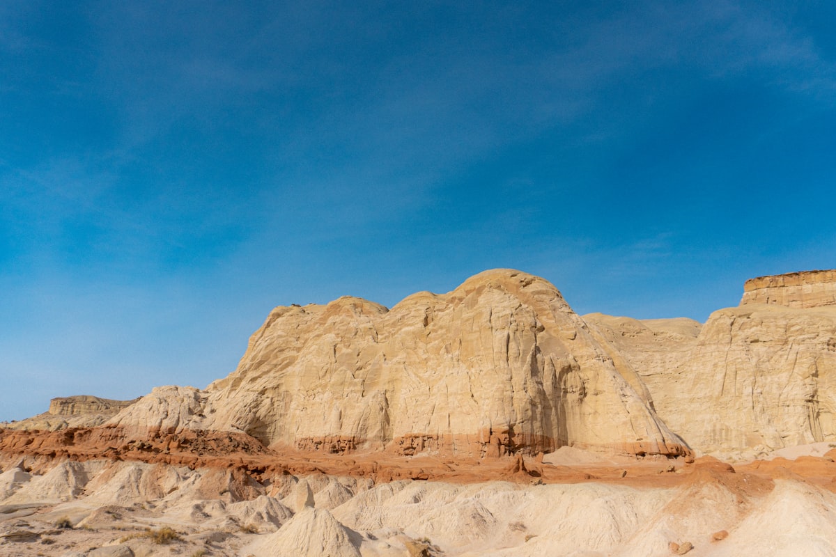 a group of mountains in the desert under a blue sky