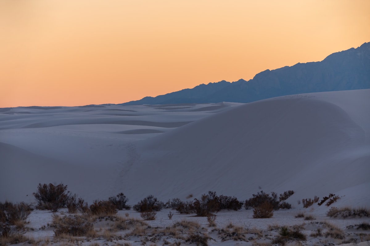 the sun is setting in the distance over the desert
