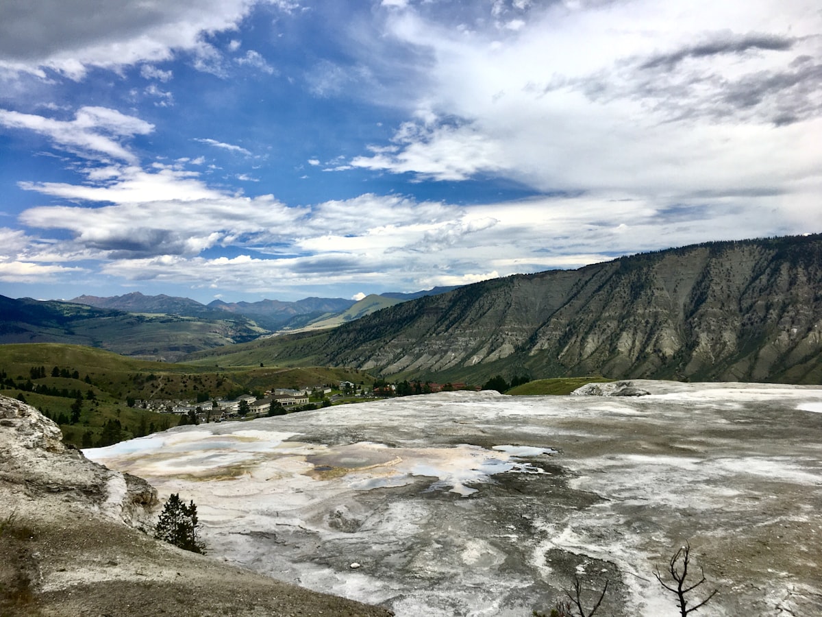 a scenic view of a valley with mountains in the background