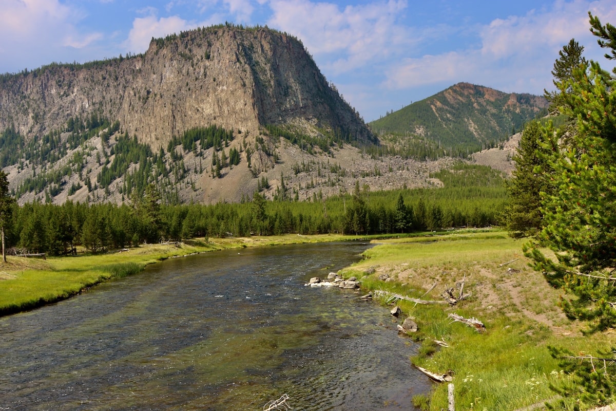 green grass field near mountain during daytime