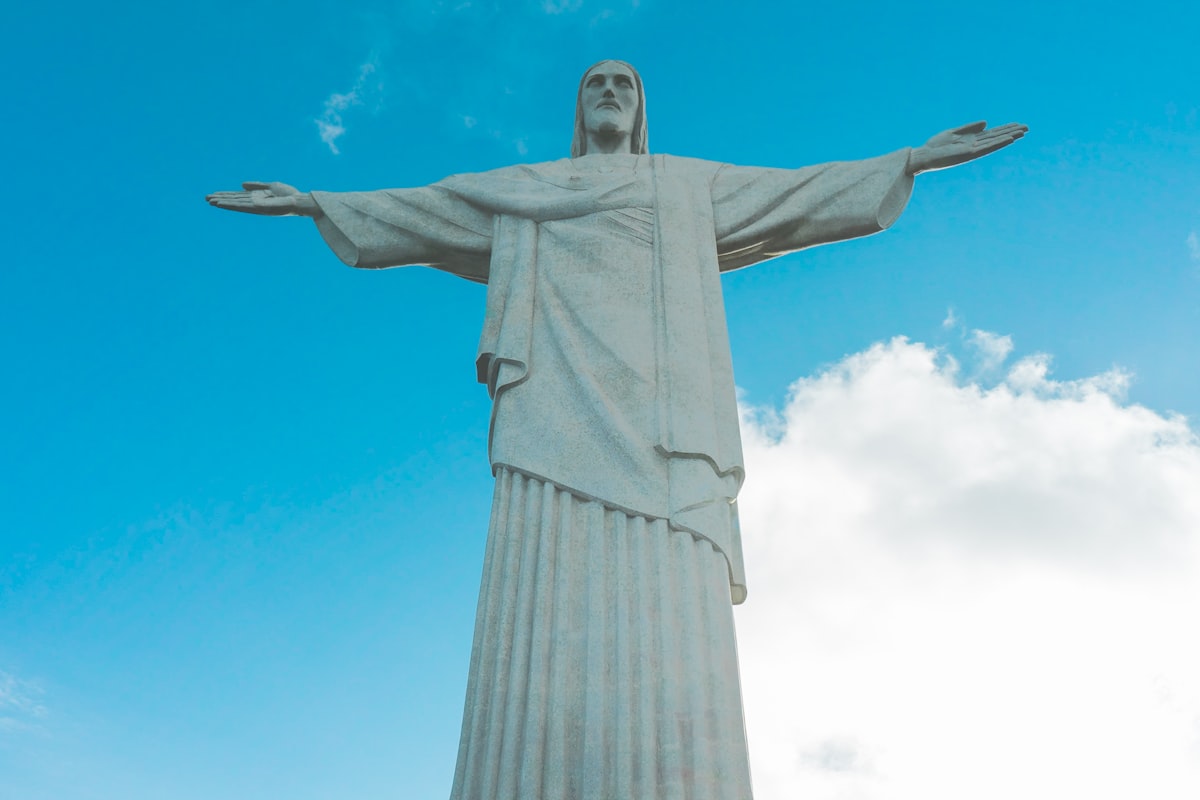 low-angle photography of Jesus Christ statue under a calm blue sky