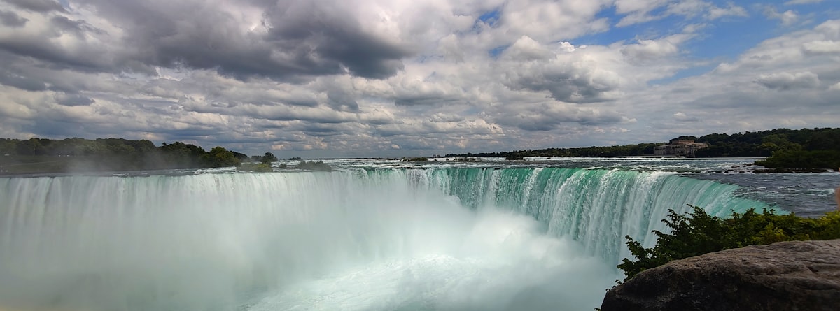 A view of a waterfall from the side of a cliff
