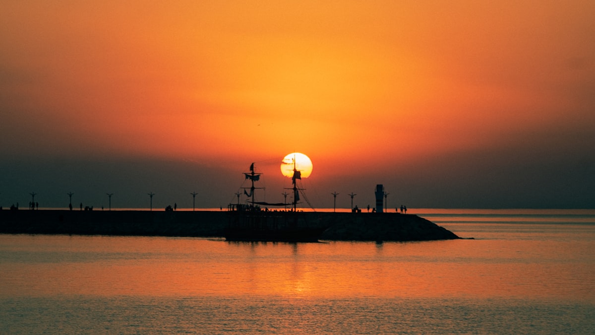 silhouette of people standing on dock during sunset