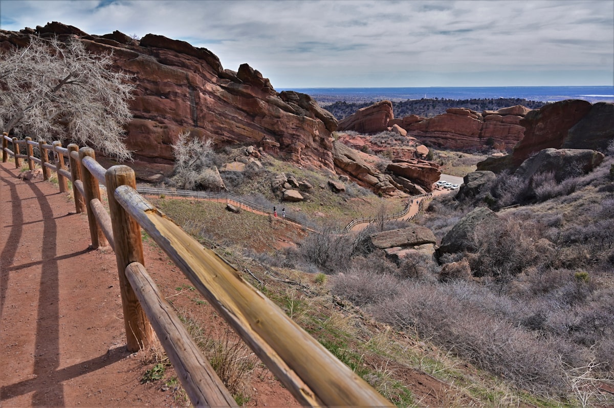 a wooden fence on the side of a dirt road