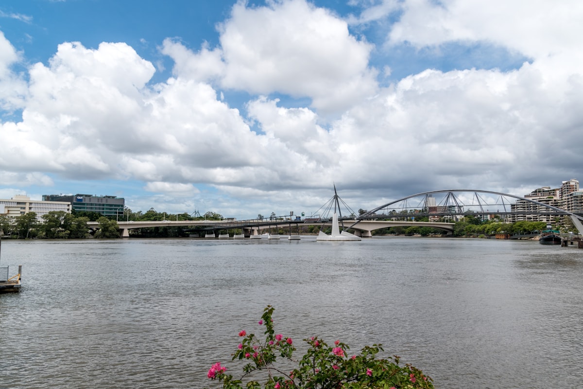 white bridge over river under blue sky and white clouds during daytime
