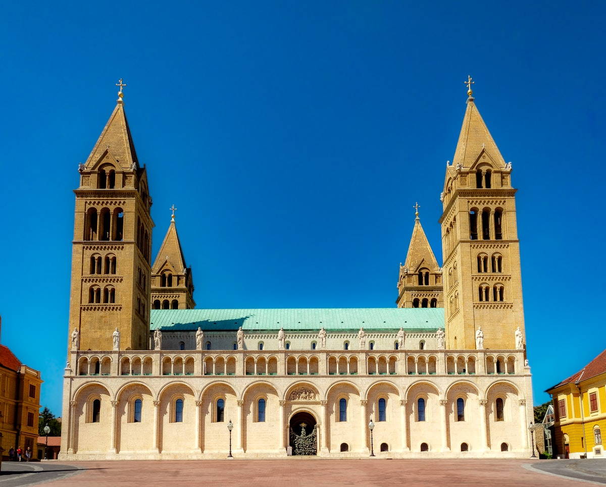 Large cathedral with two tall towers and a green roof.
