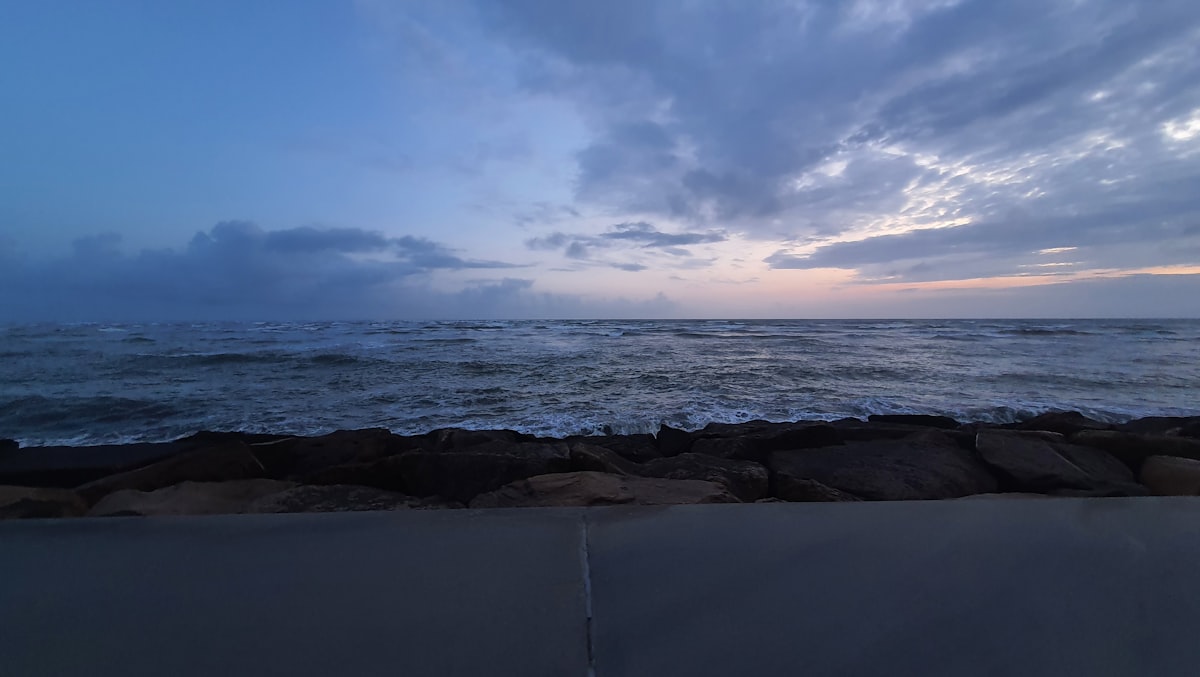 A view of a body of water with clouds in the sky