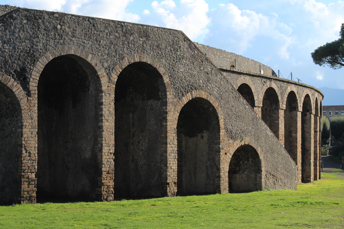 Ancient stone amphitheater arches with green grass