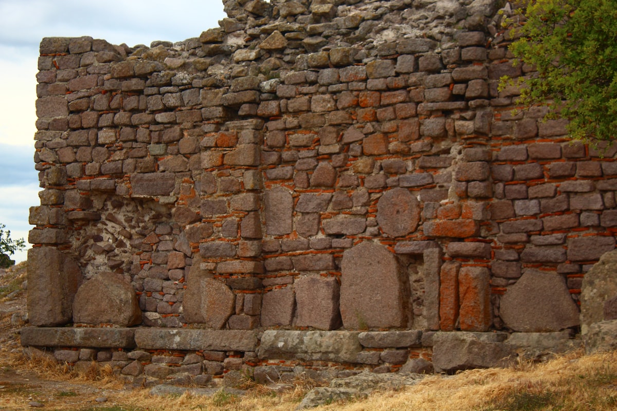 Ancient stone wall with several pillars.