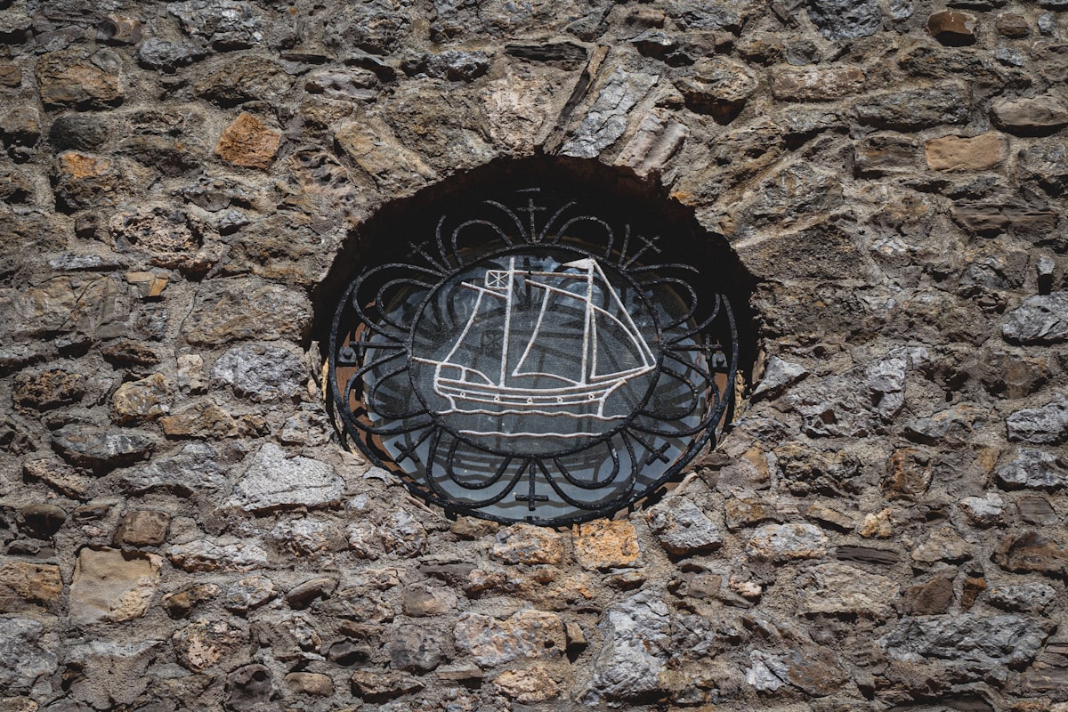 A stone wall with ship artwork.