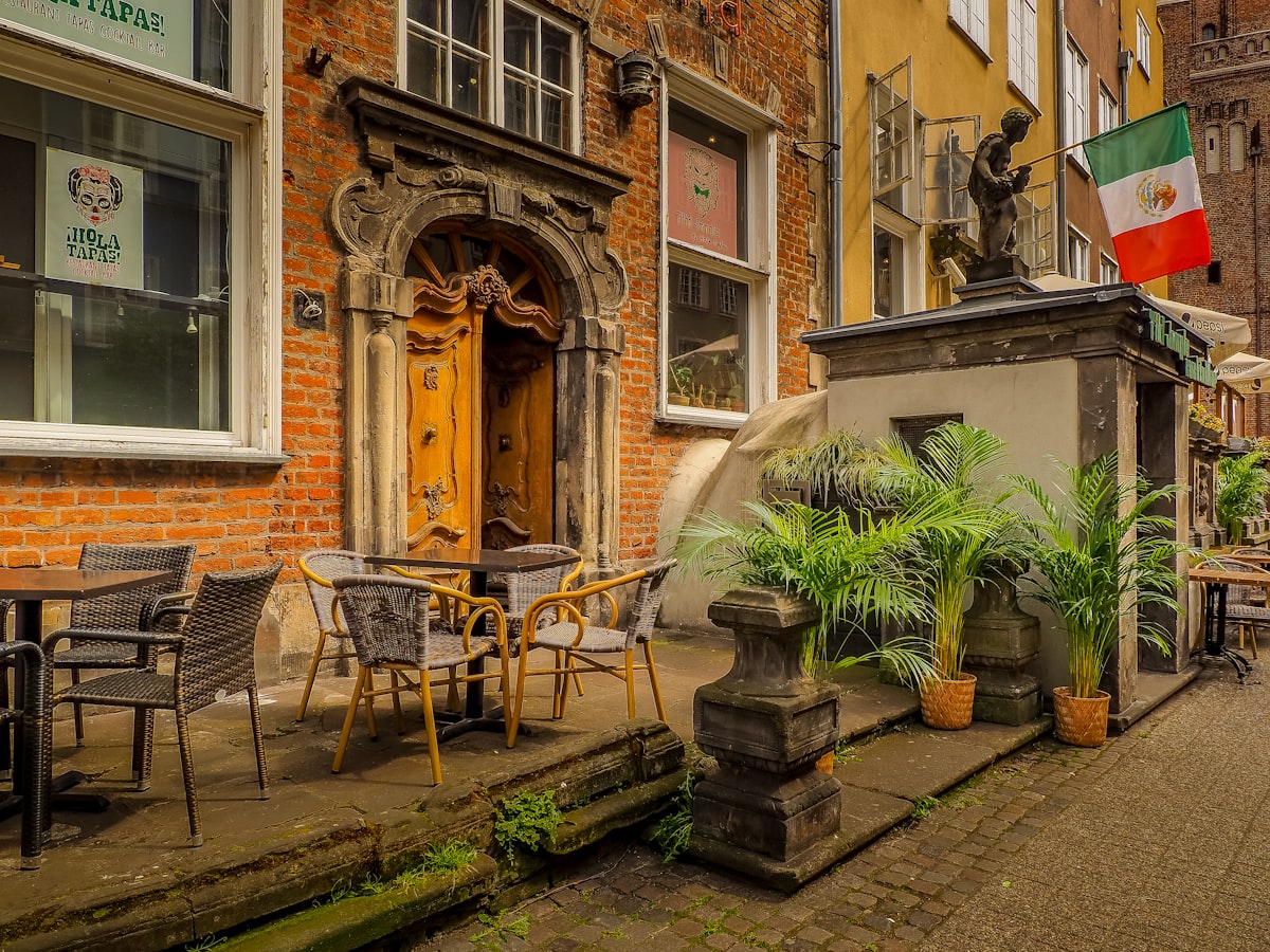 a courtyard with tables and chairs and a statue