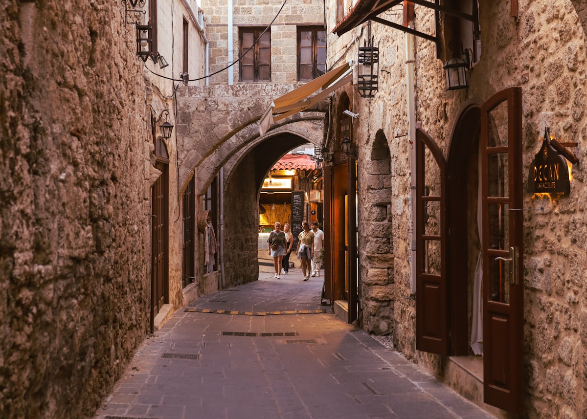 A narrow alley way with people walking down it
