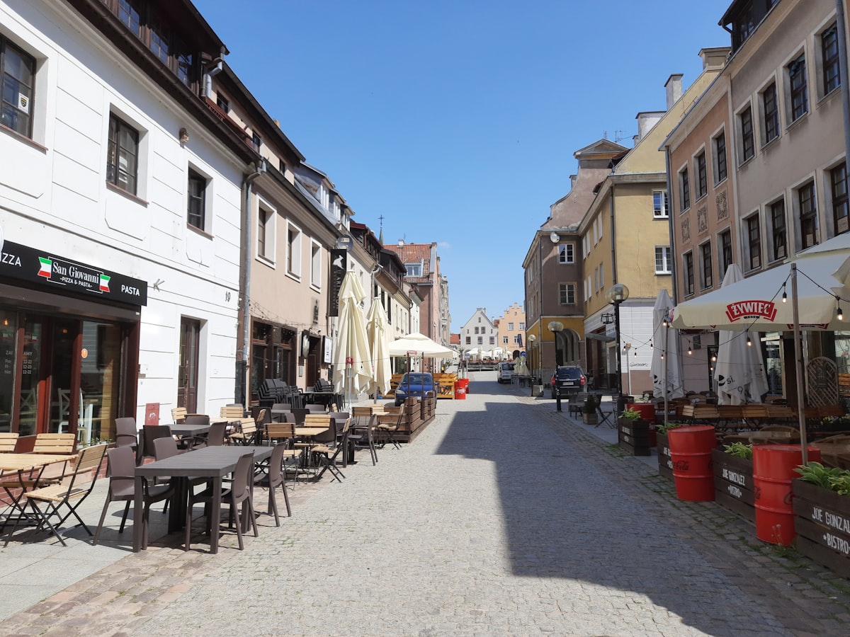 a cobblestone street lined with tables and chairs
