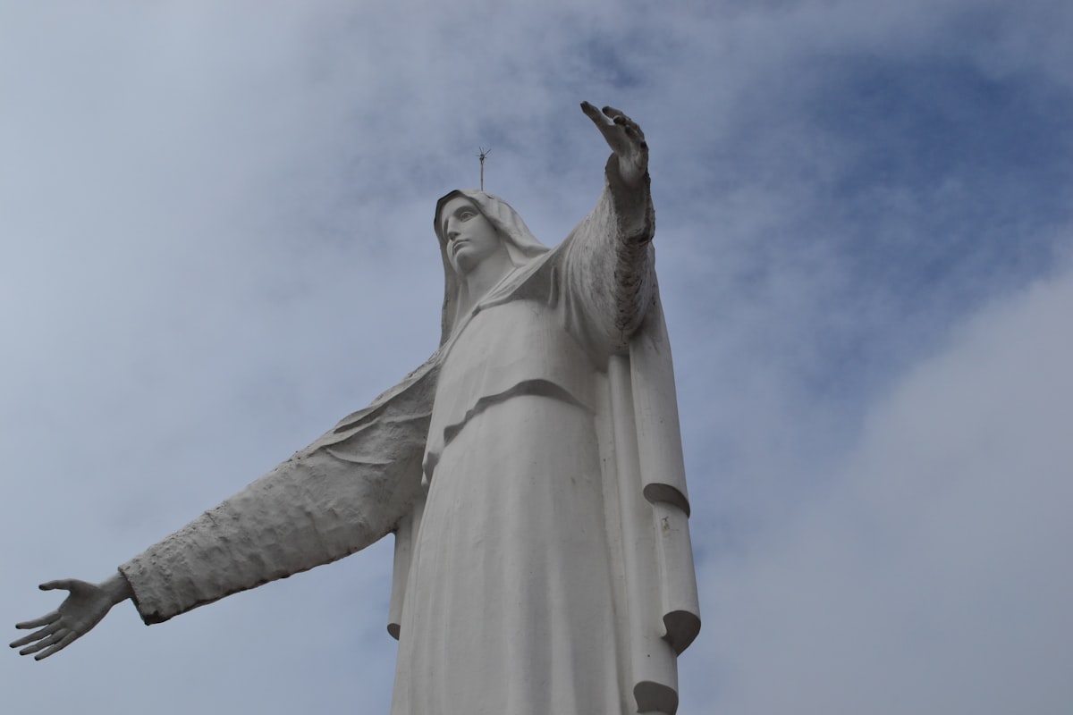 A large white statue against a cloudy sky.