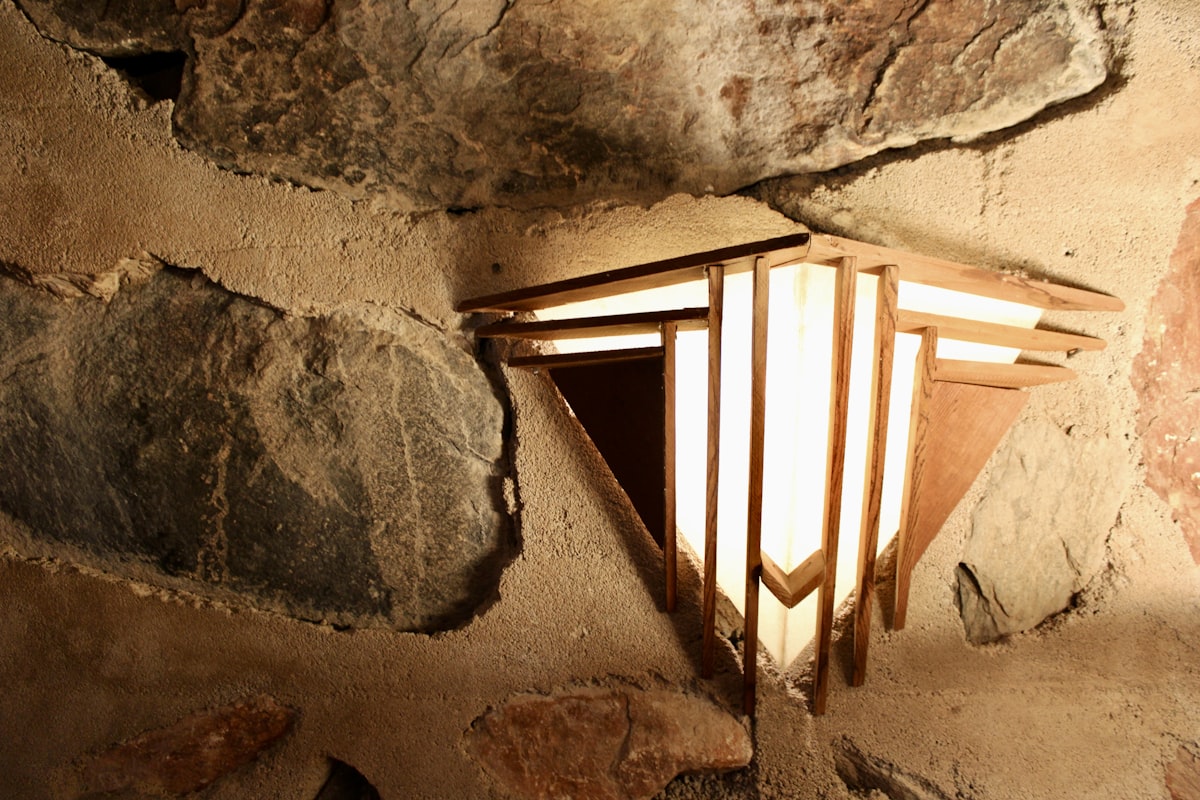 A rustic stone wall with a geometric light fixture.