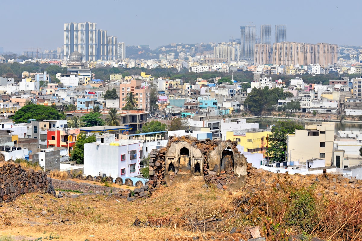 Ruins in foreground with cityscape and modern buildings behind