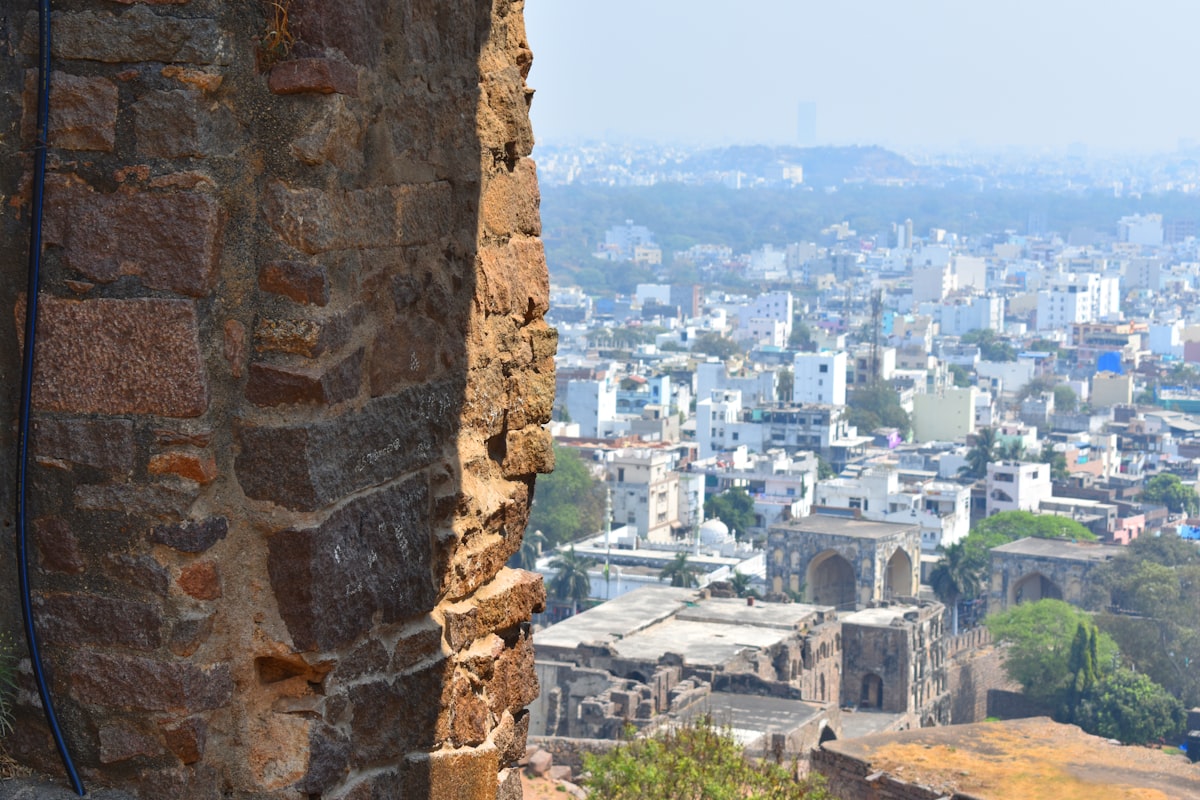 Stone wall with a cityscape in the background.
