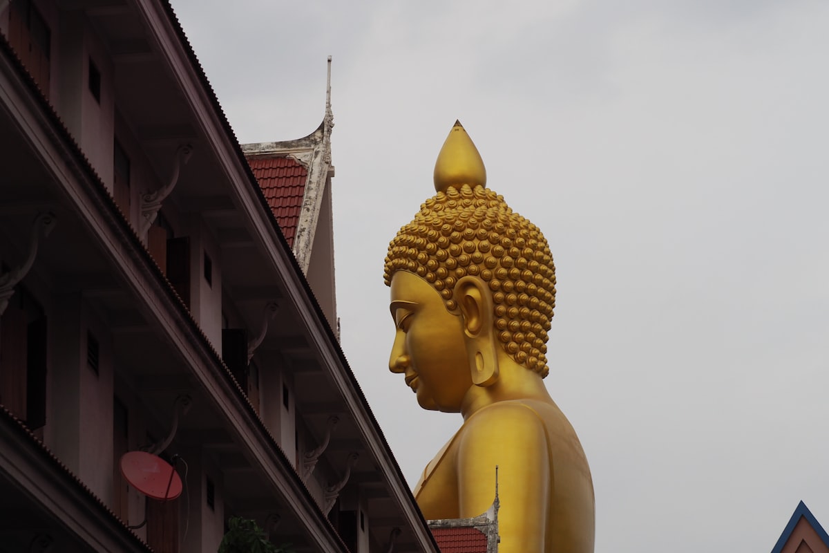 a statue of a person with a crown and a building in the background