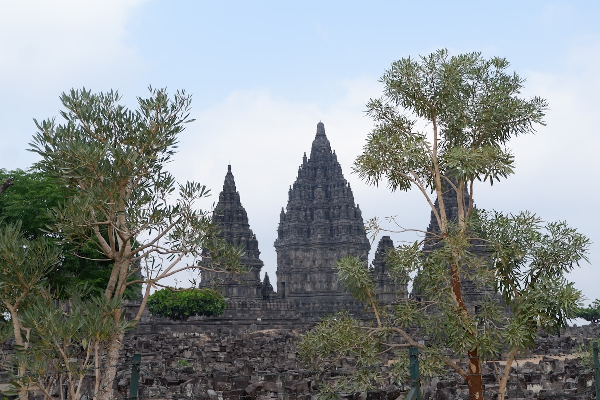Ancient stone temple complex with tall spires and trees