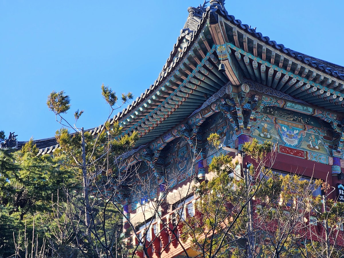 Ornate temple roof with intricate details and trees.