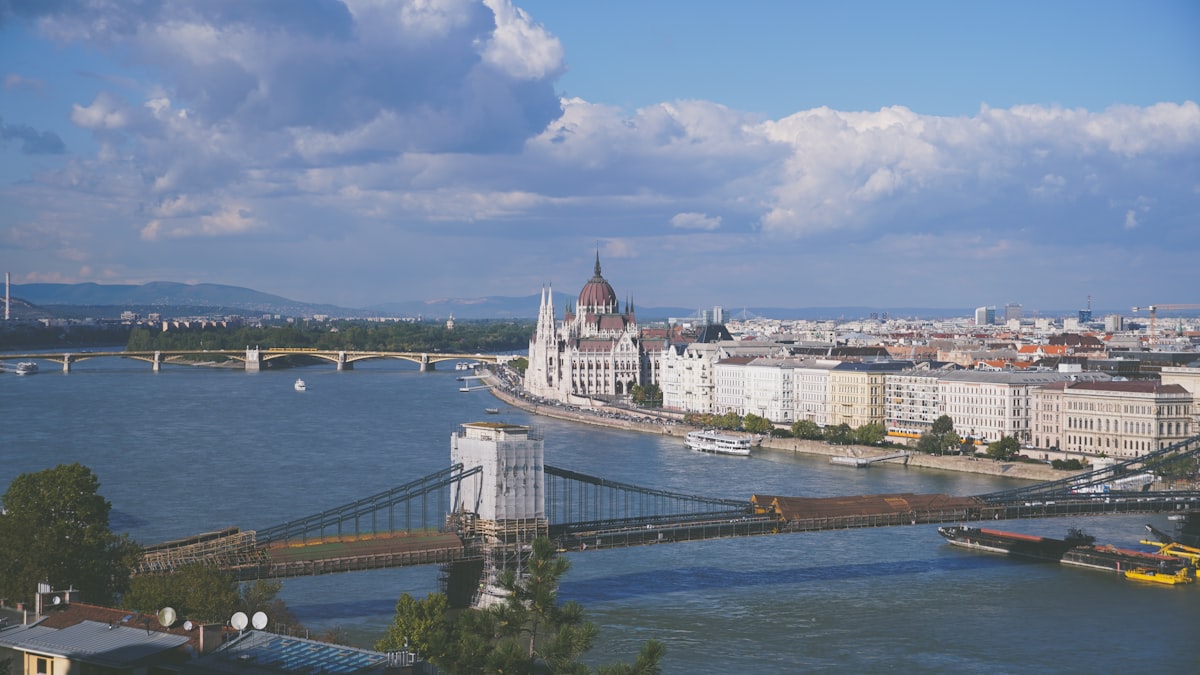 a bridge over a river with a city in the background