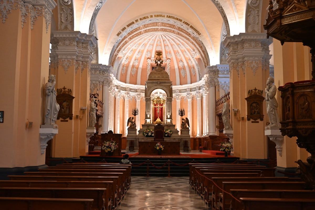 Interior of a grand church with rows of pews.
