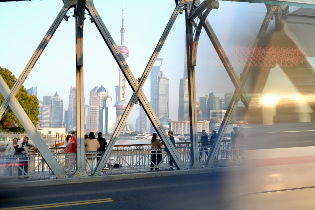People on a bridge overlooking a city skyline